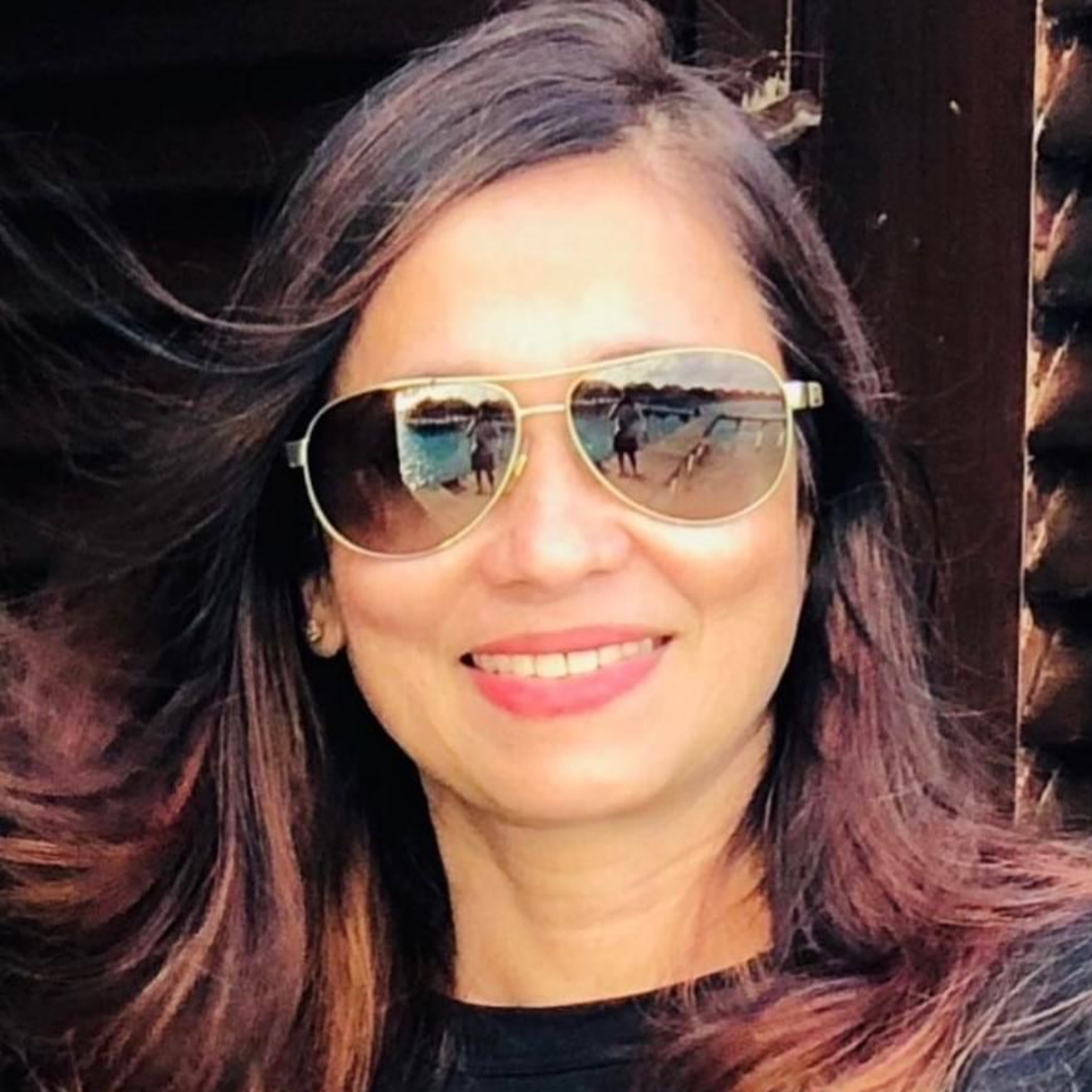 a woman wearing sunglasses and smiling